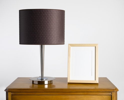 Digital picture frame on a desk by a lamp